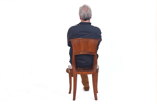 rear view of a man sitting on chair arms crossed on white background