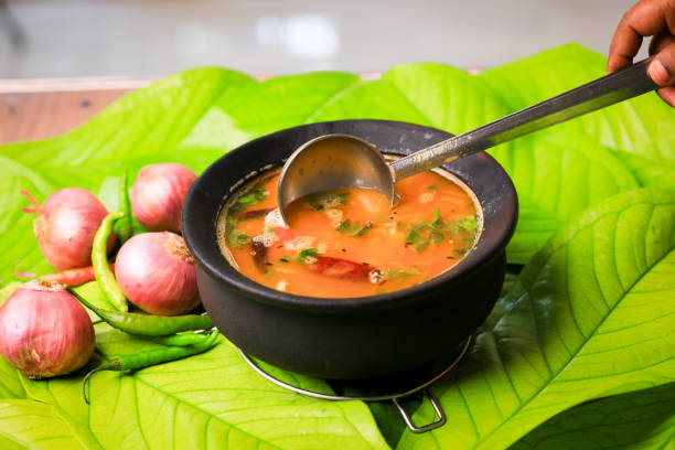 south indian famous rasam,sambar served in a traditional mud pot closeup with selective focus and blur - tomato curry imagens e fotografias de stock