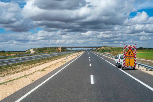istock Highway maintenance vehicle with a panel warning of a lane closure on a motorway. 1391461540