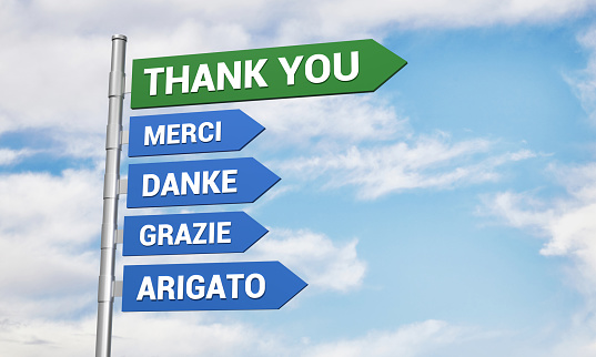 Thank You in Different Languages Road Direction Signs On Blue Sky Background. Business Concept.