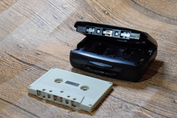 Retro audio cassettes next to a portable player to play compact cassettes.