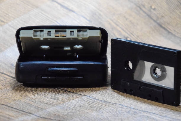 Retro audio cassettes next to a portable player to play compact cassettes.