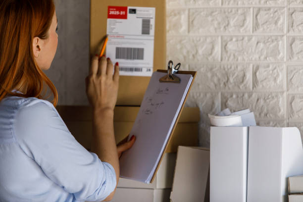 istock Young female entrepreneur reading a serial number on a label from a package 1391464081