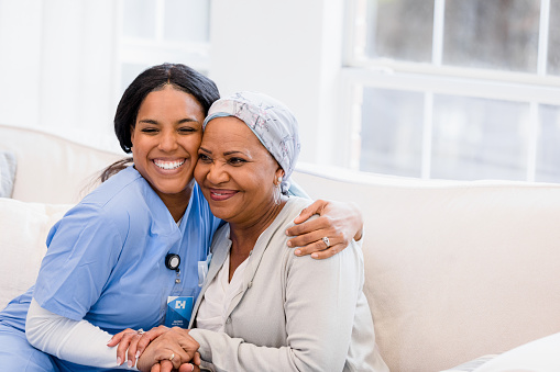 The proud home healthcare nurse embraces her patient as she provides good news on her improvement.