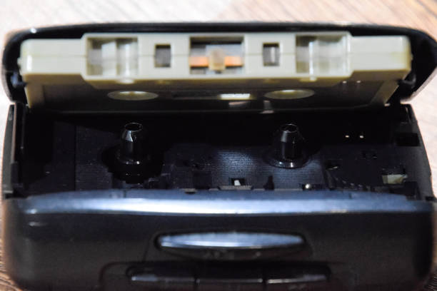 istock Retro audio cassettes next to a portable player to play compact cassettes. 1391464616