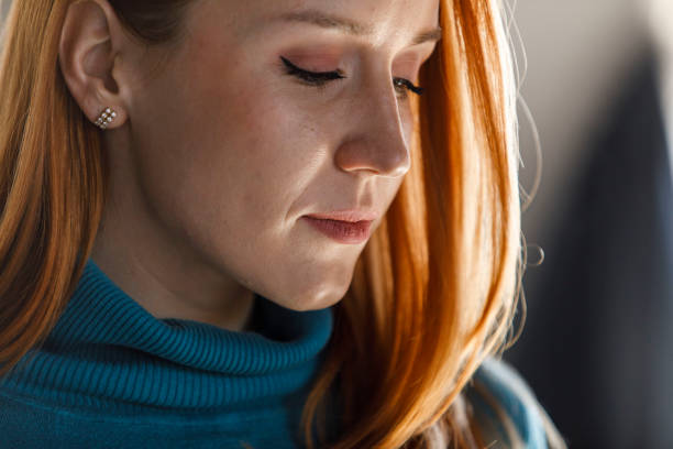 istock Portrait of beautiful redhead slightly smiling, looking down, contemplating 1391465266
