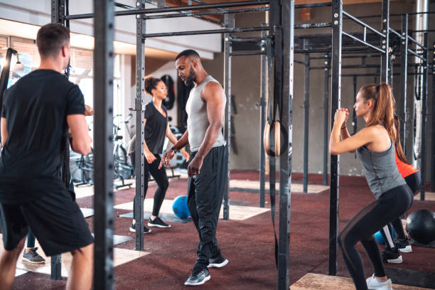 istock Male instructor with athletes exercising at gym 1391465453