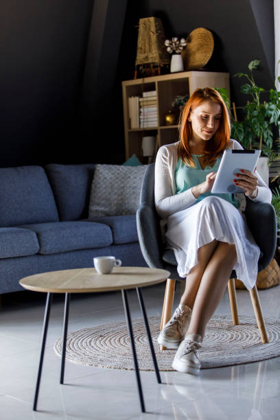istock Young woman scrolling through social media on digital tablet while having morning coffee 1391465460