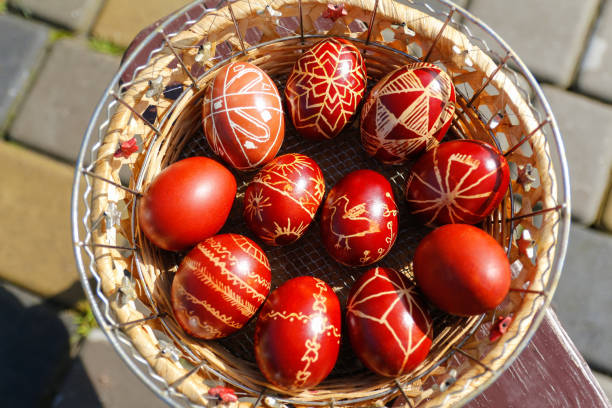 istock Defocus Closeup of basket of colored red eggs, Easter holiday concept. Modern painted easter eggs. Nature background, garden. Collection of pysanka or krashanka. Top view. Out of focus 1391465607