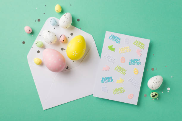 istock Top view photo of white open envelope with glowing confetti multicolored easter eggs and paper card with inscriptions happy easter egg and bunny silhouettes on isolated teal background 1391466078
