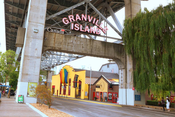 Road Leading To Granville Island Vancouver, British Columbia, Canada - July 9, 2018: The entrance welcoming visitors to Vancouver, British Columbia's Granville Island in Vancouver, British Columbia. Granville island is a popular destination for residents and tourists for shopping and restaurants. granville island stock pictures, royalty-free photos & images