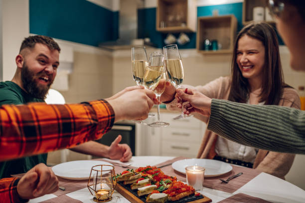 istock Friends sitting at a kitchen table and toasting during a dinner part 1391467806