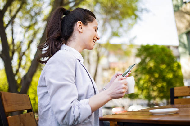 istock Young Caucasian woman sitting using phone for text messaging 1391467853