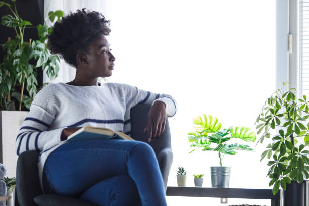 istock Young woman contemplating about the book she is reading 1391468105
