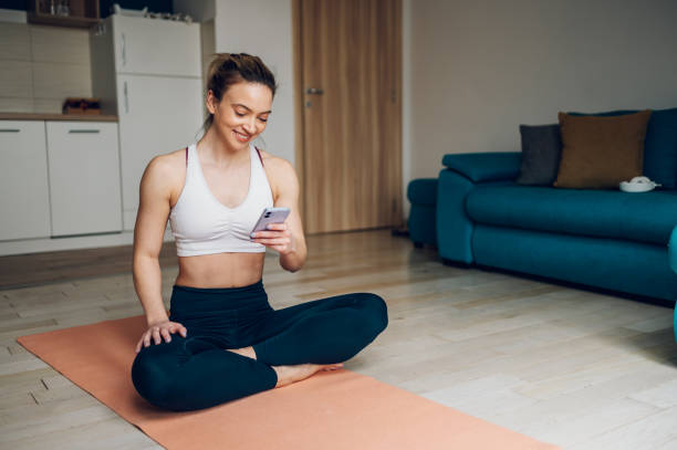 istock Woman using smartphone after training at home 1391471143