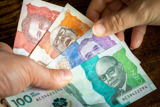 argent colombien, beaucoup de billets de banque pesos remis à une autre personne - beak buying currency exchanging photos et images de collection