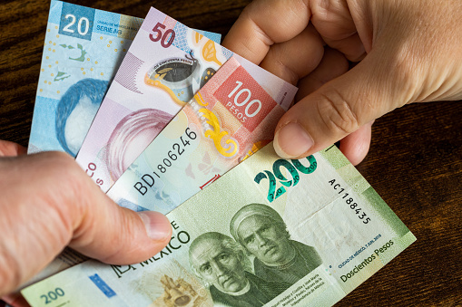 Dinero mexicano, muchos billetes de pesos entregados a otra persona photo