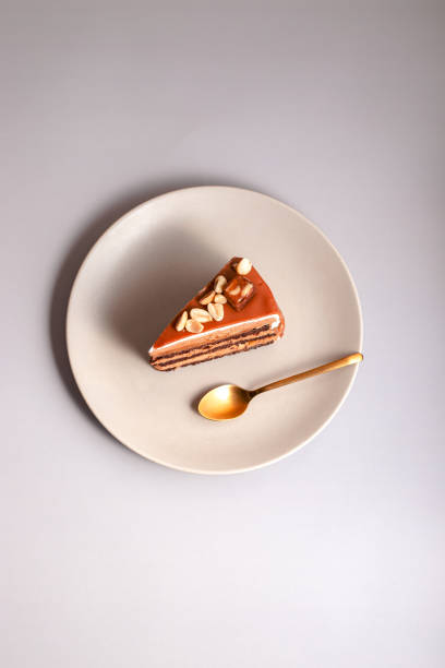 istock caramel cake decorated peanuts served on beige plate on beige background. close up with copy space 1391472069