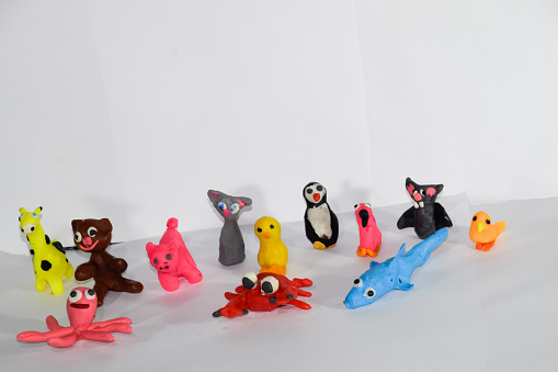 A set of plasticine toys on a white background. Toys made of plasticine in the form of animals.
