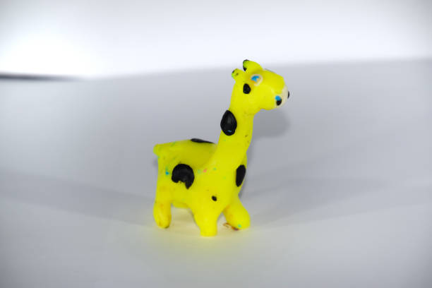 istock Plasticine giraffe. Plasticine toys on white background. 1391472852
