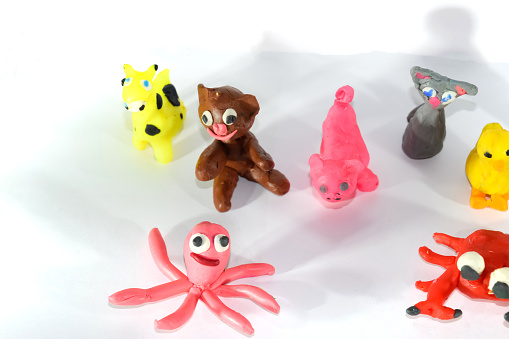 A set of plasticine toys on a white background. Toys made of plasticine in the form of animals.