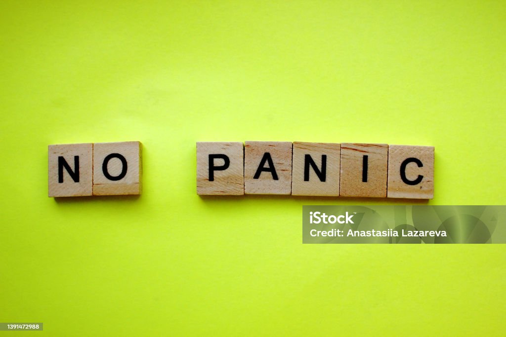 Word No panic on a yellow background. The inscription is made of wooden cubes. Danger, panic. A Call to Remain Calm. Copy space. Top view. Flat lay. Word No panic on a yellow background. The inscription is made of wooden cubes. Danger, panic. A Call to Remain Calm. Copy space. Top view. Flat lay Anxiety Stock Photo