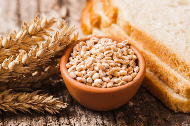 istock Rye bread with seeds lies on a dark wooden board on a light table. 1391475460