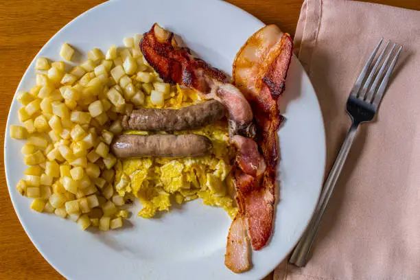 sausage and bacon with scrambled eggs and a side of hash browns