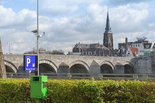 Maastricht. Limburg - Netherlands 10-04-2022. Parking sign on the canal embankment in the city of Maastricht. View of the old tower and bridge