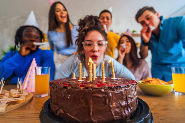 istock Woman blowing birthday candles 1391481724
