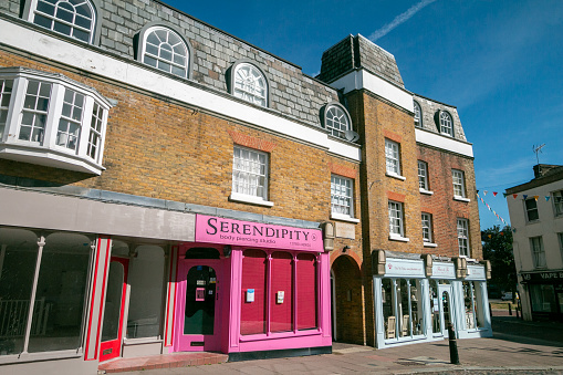 Serendipity Body Piercing Shop on Crow Lane at Rochester in Kent, England. Other shops are visible.