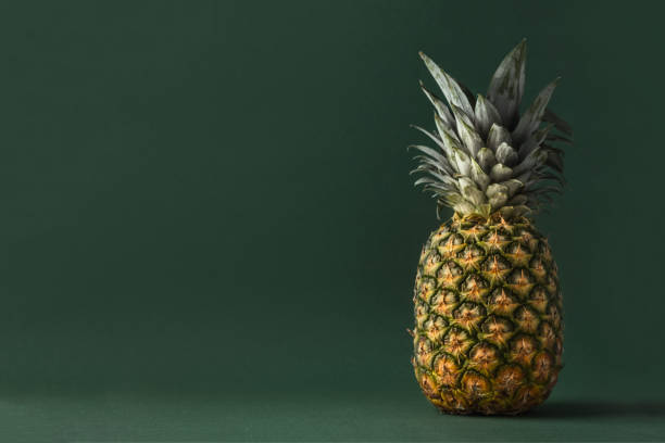 istock Whole pineapple on the dark green background 1391482482