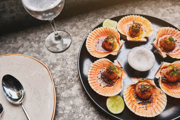 istock Scallops with flamed shells on a black plate. Luxury restaurant food. Seafood, selective focus. 1391487732