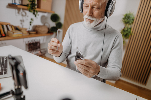 Retired man using his smartphone for vlogging