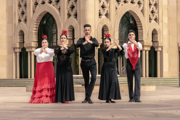 General frontal shot of 5 flamenco dancers playing hand clapping in a group