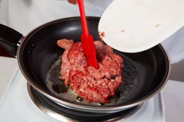 Preparation of ground beef with the traditional Colombian hogao or criollo sauce (salsa criolla) made of onion, tomato, peppers and cilantro