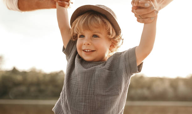 istock Cute boy holding hands with parents in nature 1391504802