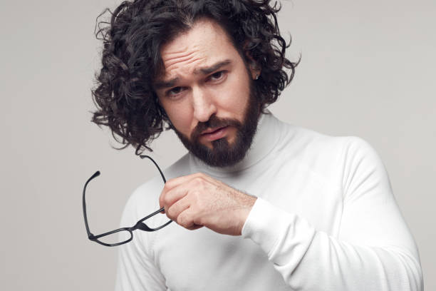 istock Serious man with curly hair and glasses 1391504880