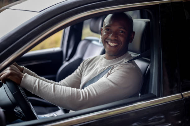 istock Happy man driving a car and smiling 1391517619