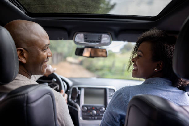 Happy couple going on a road trip in their car