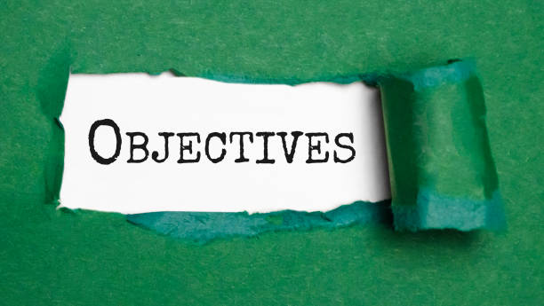 Goals and Objectives words written under torn paper. stock photo