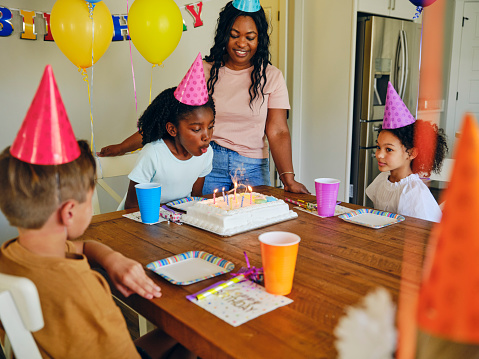 A group of children celebrating a birthday with a party in a home.