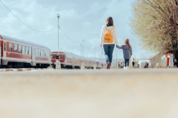 istock Mother and Daughter Walking Together on a Train Station Platform 1391530573