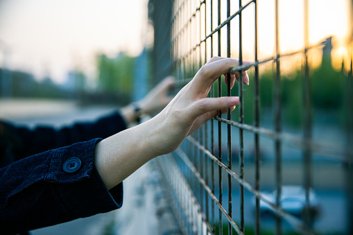 Woman's hand holding the fence