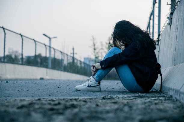 istock lonely girl sitting on ground 1391534339