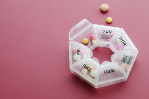 top view of medical pills in a pill box on color background .