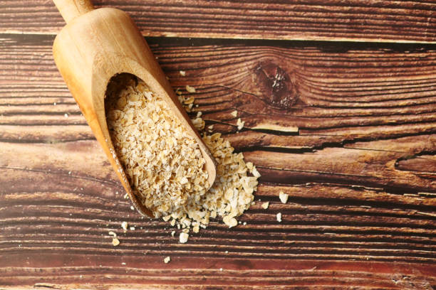 istock Close up of oats flakes on spoon on table 1391537760