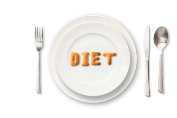 DIET letters written by cookies on white plate with silverware.\nDiet concepts.
