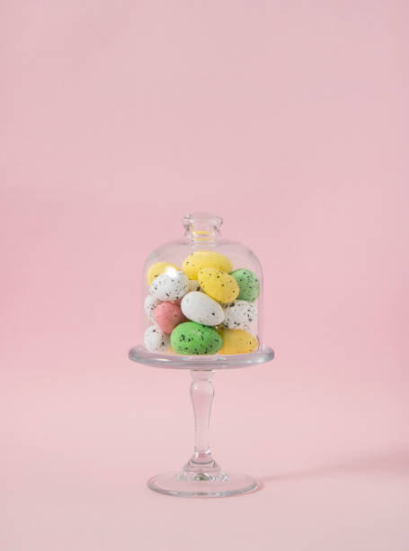 istock Creative Easter painted eggs in glass bowl. Pastel pink background. Spring decoration. 1391545350