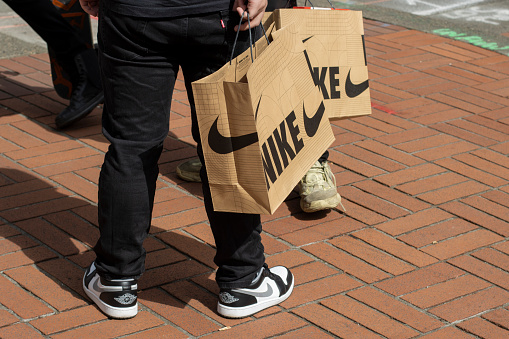 Portland, OR, USA - Apr 1, 2022: Nike fans who have just purchased new release sneakers from Nike's Flagship Store in downtown Portland, Oregon, are seen on the streets with their nike shopping bags.